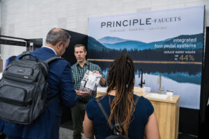 An exhibitor showing his product information to customers at KBIS