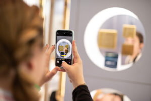 Women takes a photo of product through her iPhone at KBIS 2023.