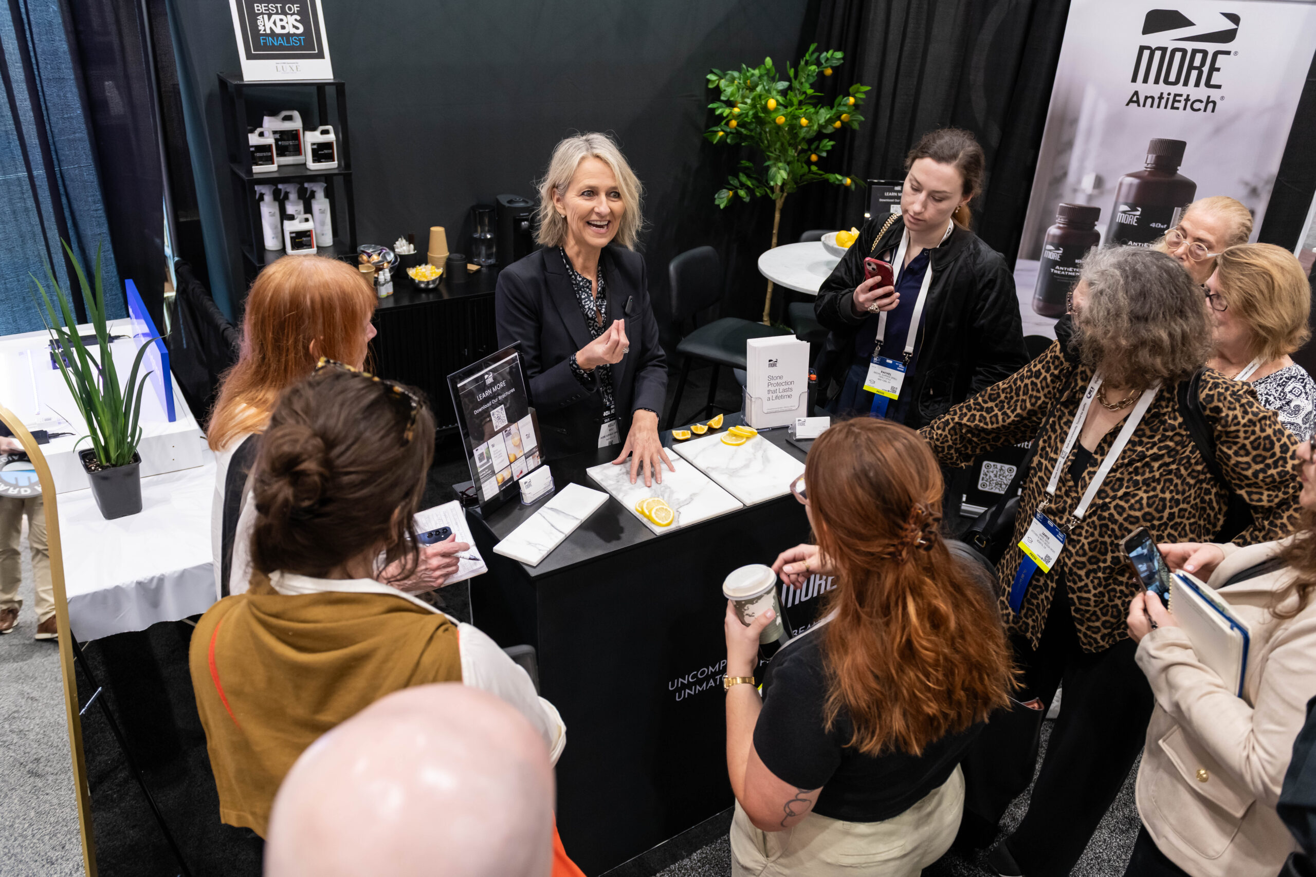 Woman taking a photo of another woman in front of products at KBIS 2024